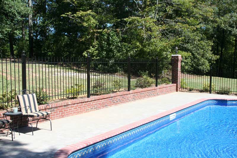 Iron Fence Around a Pool in  Conjunction with a Brick Knee Wall and Columns